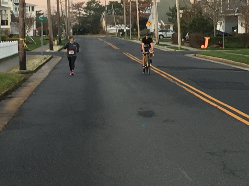 Triathletes running and biking on the course. 